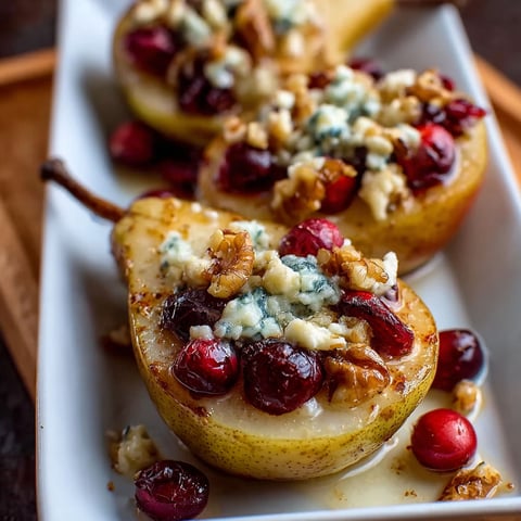 A plate of baked pears with cranberries, honey, walnuts and blue cheese.